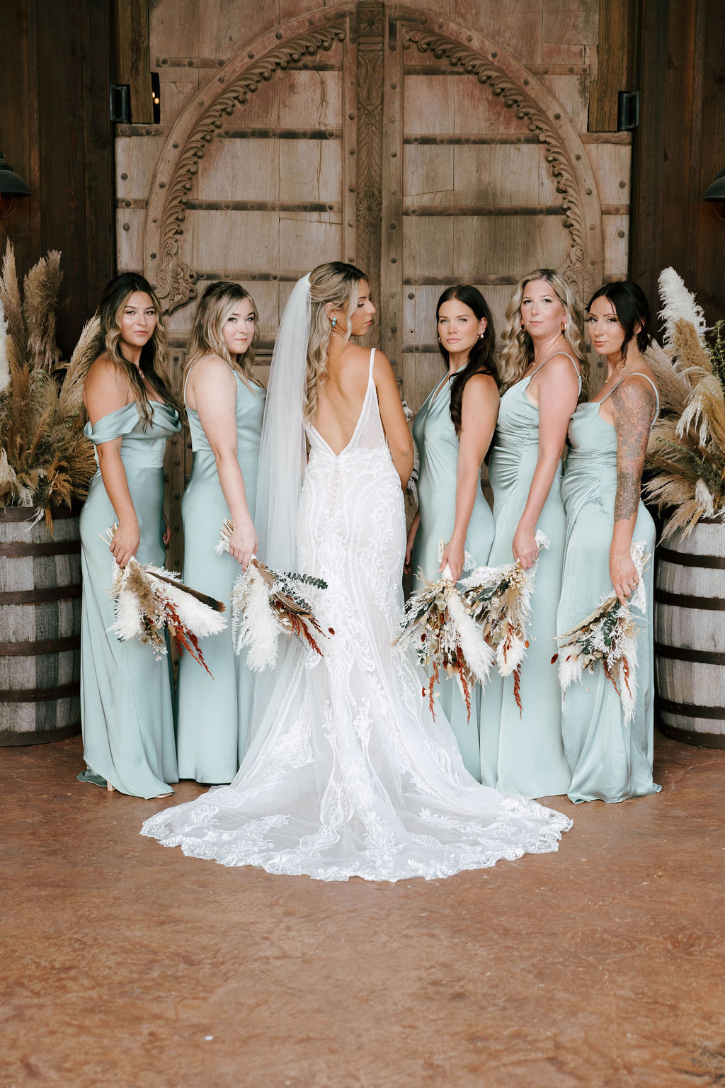 Bridal Party standing in front of rustic barn door at The Lucky Spur Ranch